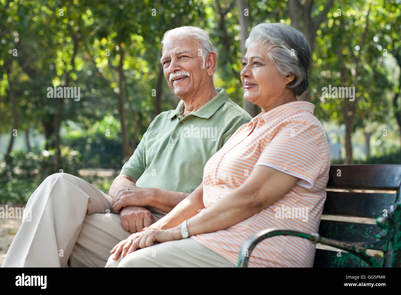 Happy couple relaxing on park bench Stock Photo - Alamy