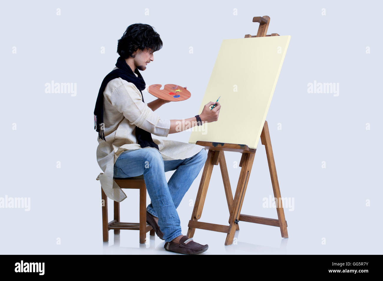Young male artist about to paint against colored background Stock Photo ...