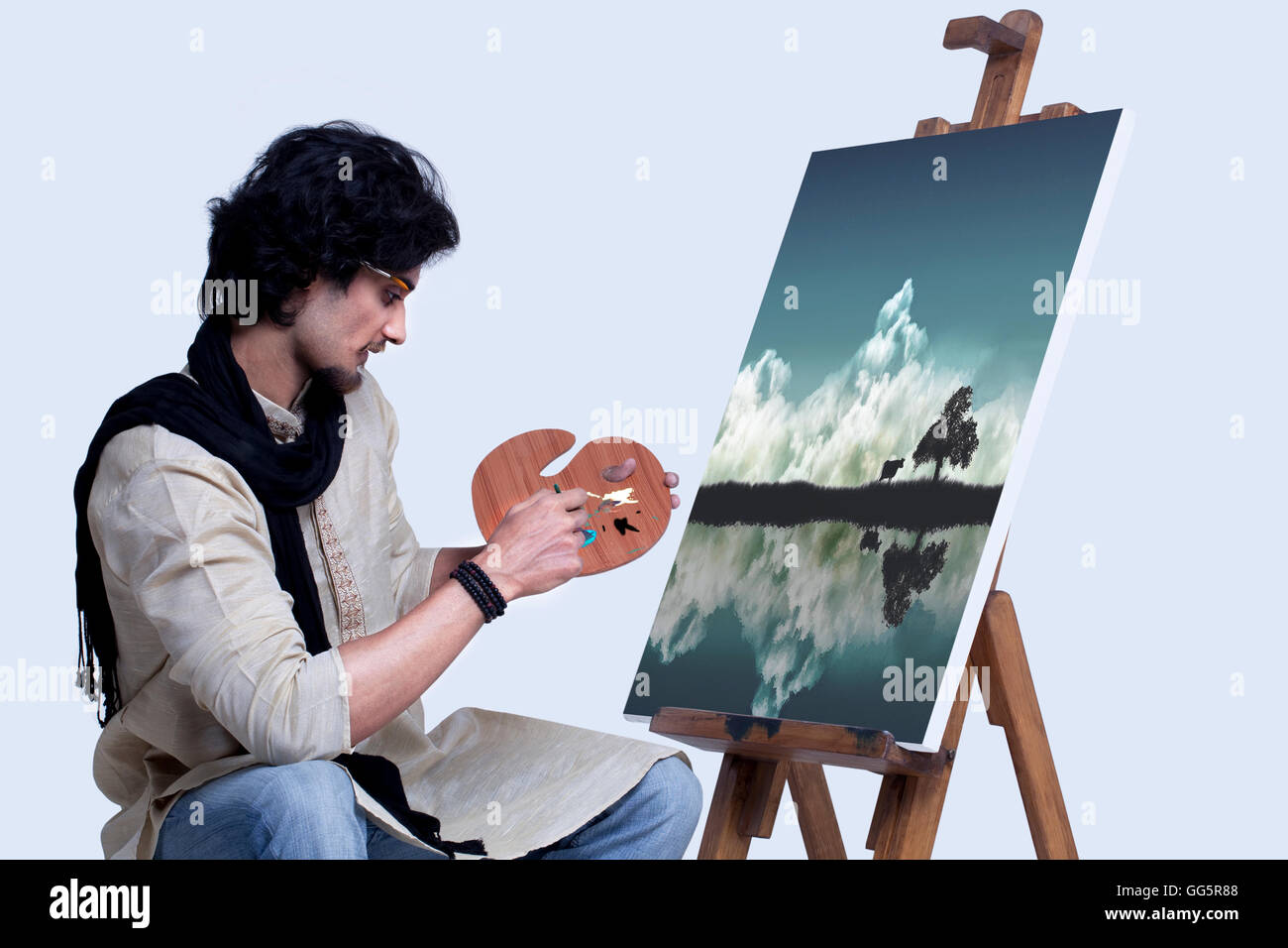 Young artist painting against colored background Stock Photo