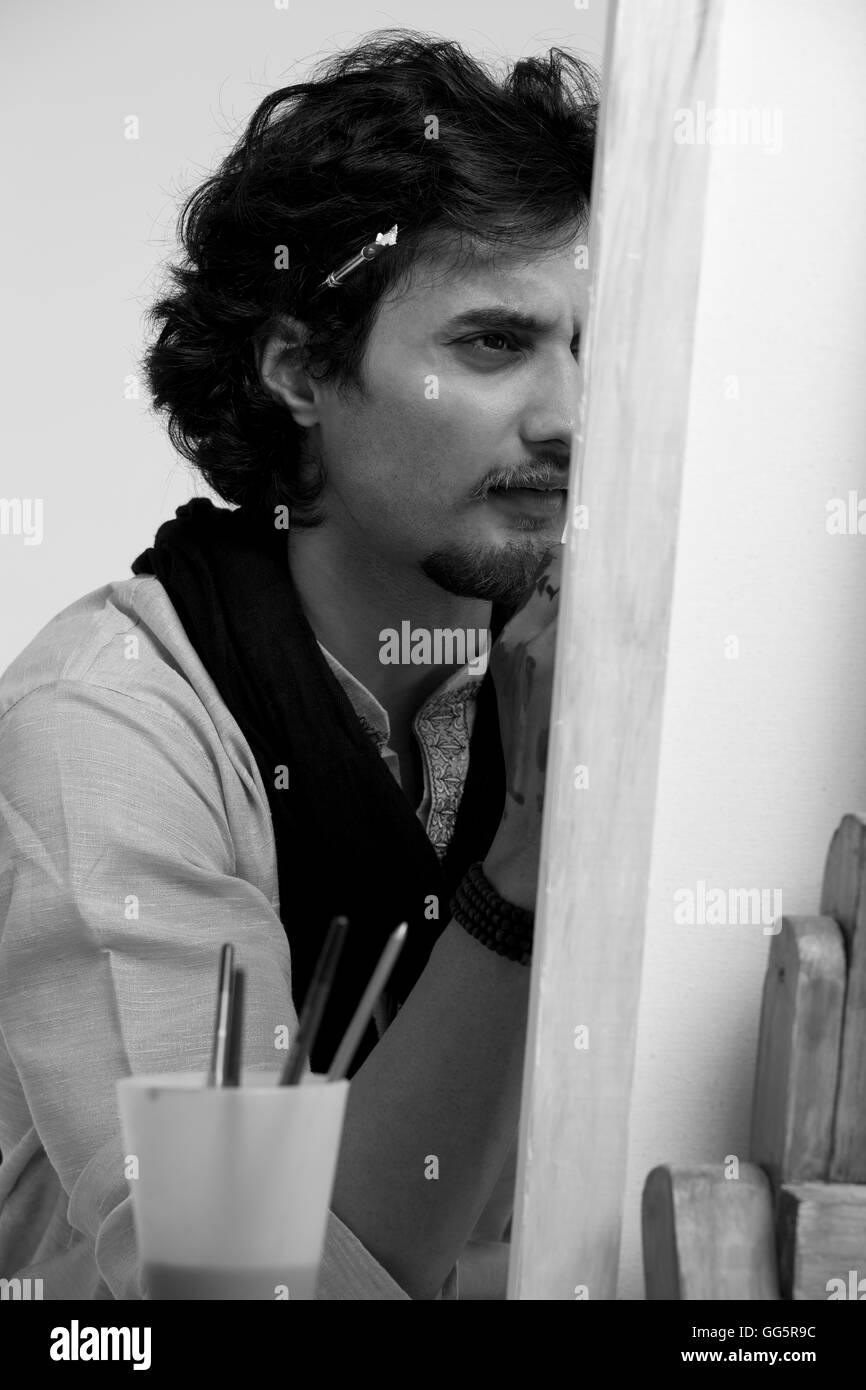 Black and white image of handsome male artist painting Stock Photo