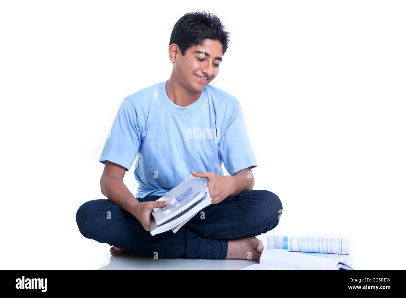Smiling teenage boy with books against white background Stock Photo