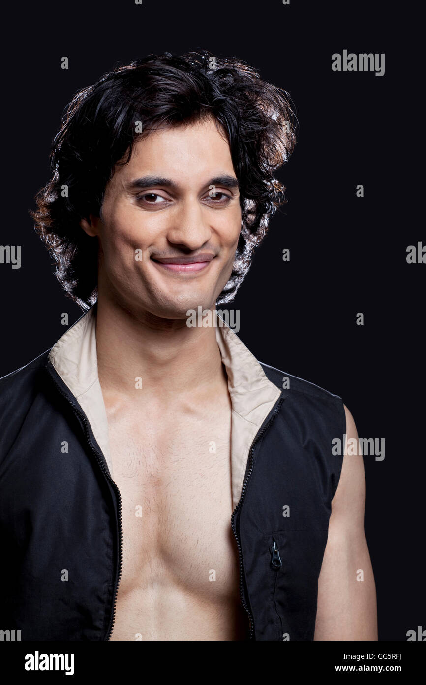 Portrait of smiling young man against black background Stock Photo - Alamy