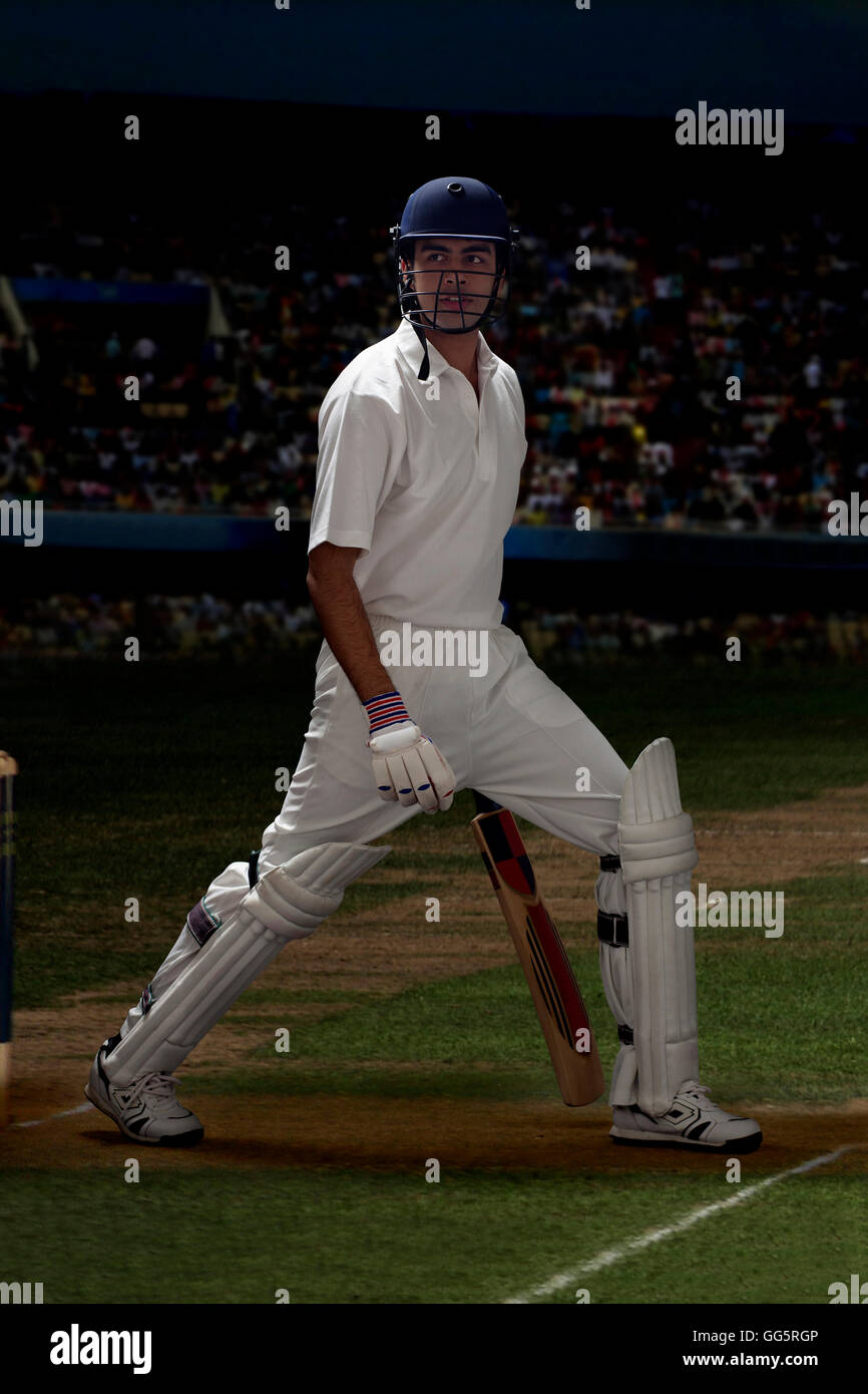 Full length of batsman stretching on cricket field Stock Photo