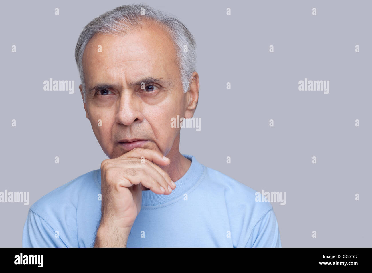 Close-up of thoughtful man over gray background Stock Photo