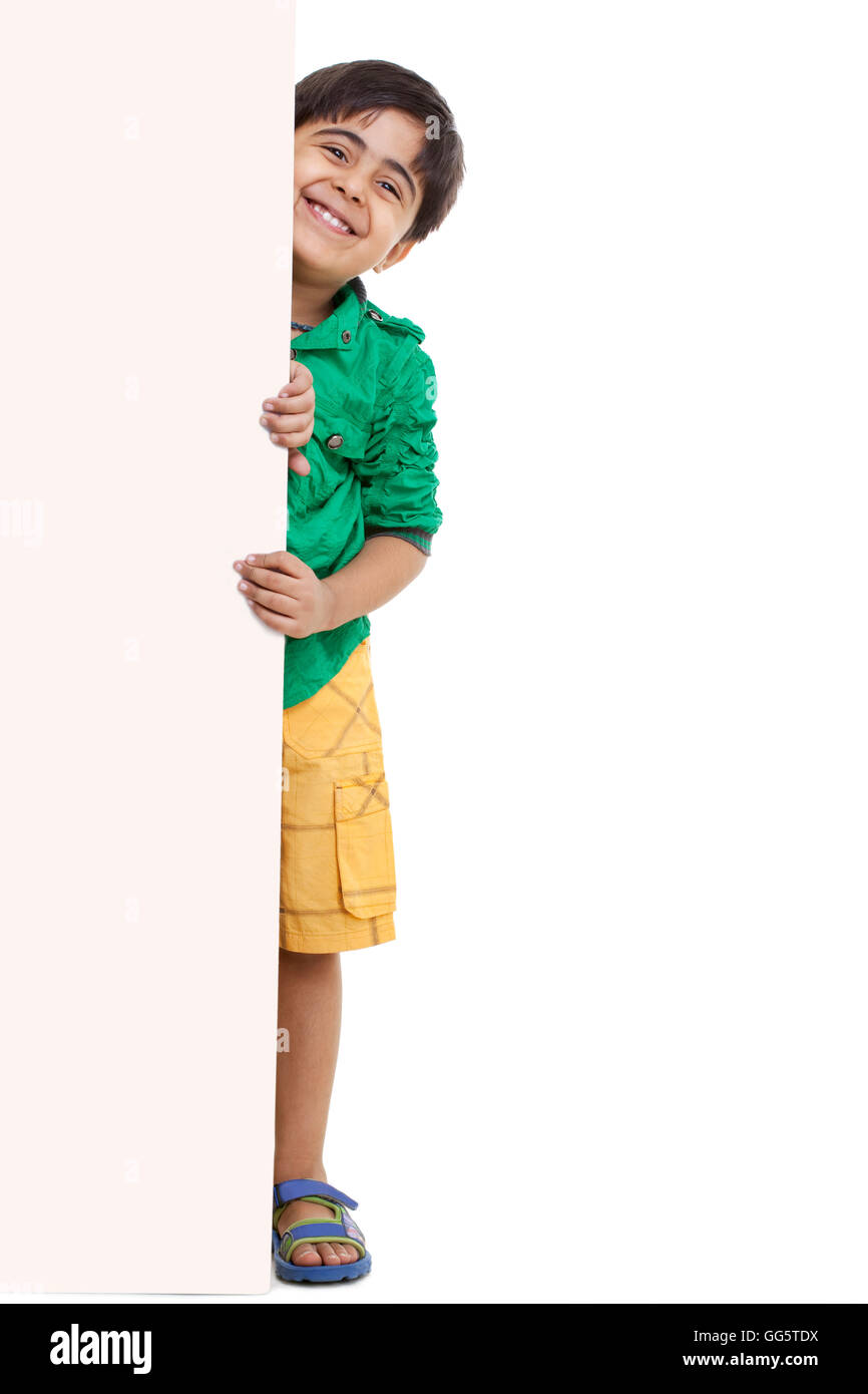 Portrait of playful little boy standing by blank board Stock Photo - Alamy