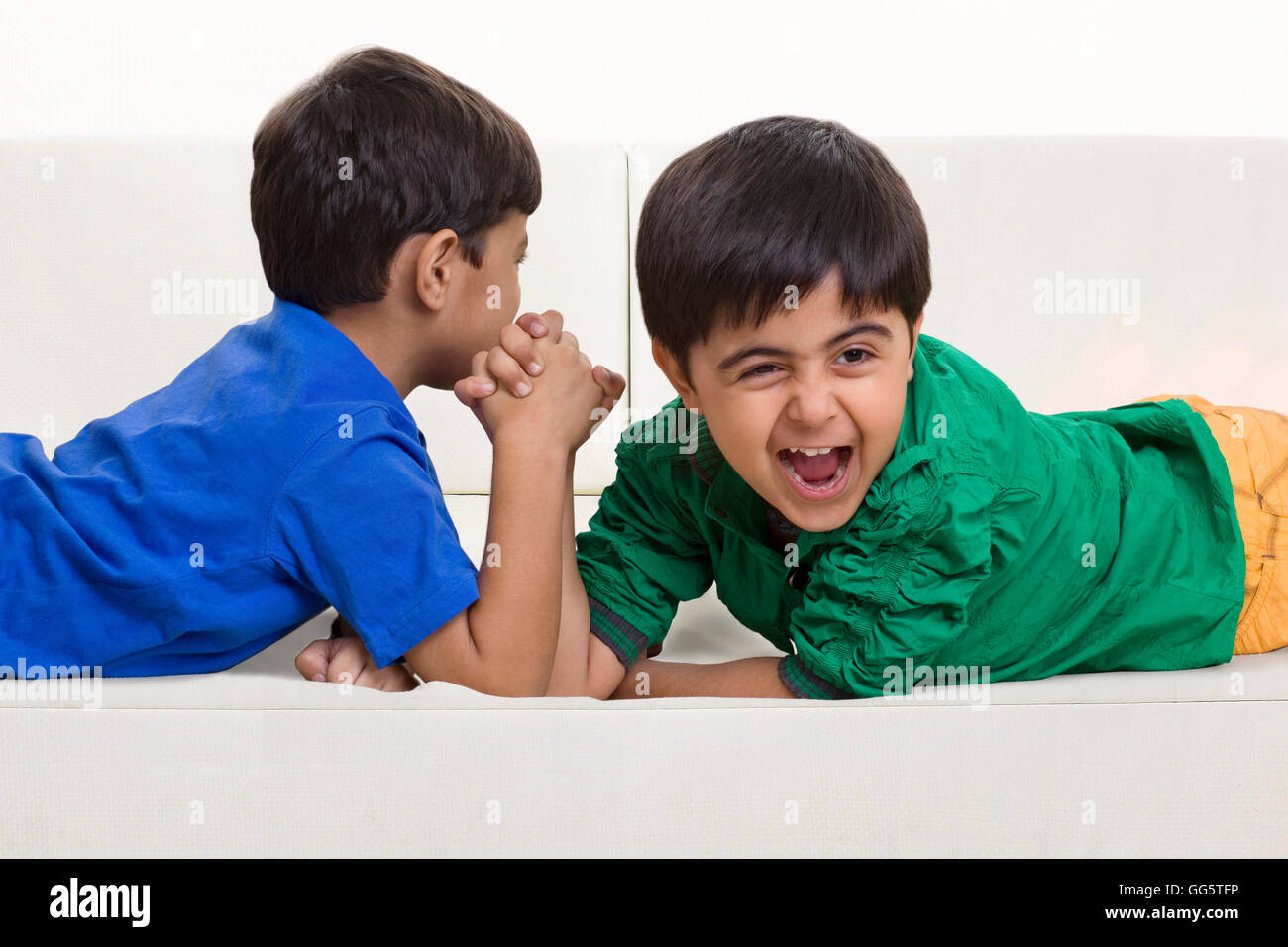 Brothers arm wrestling on sofa Stock Photo Alamy