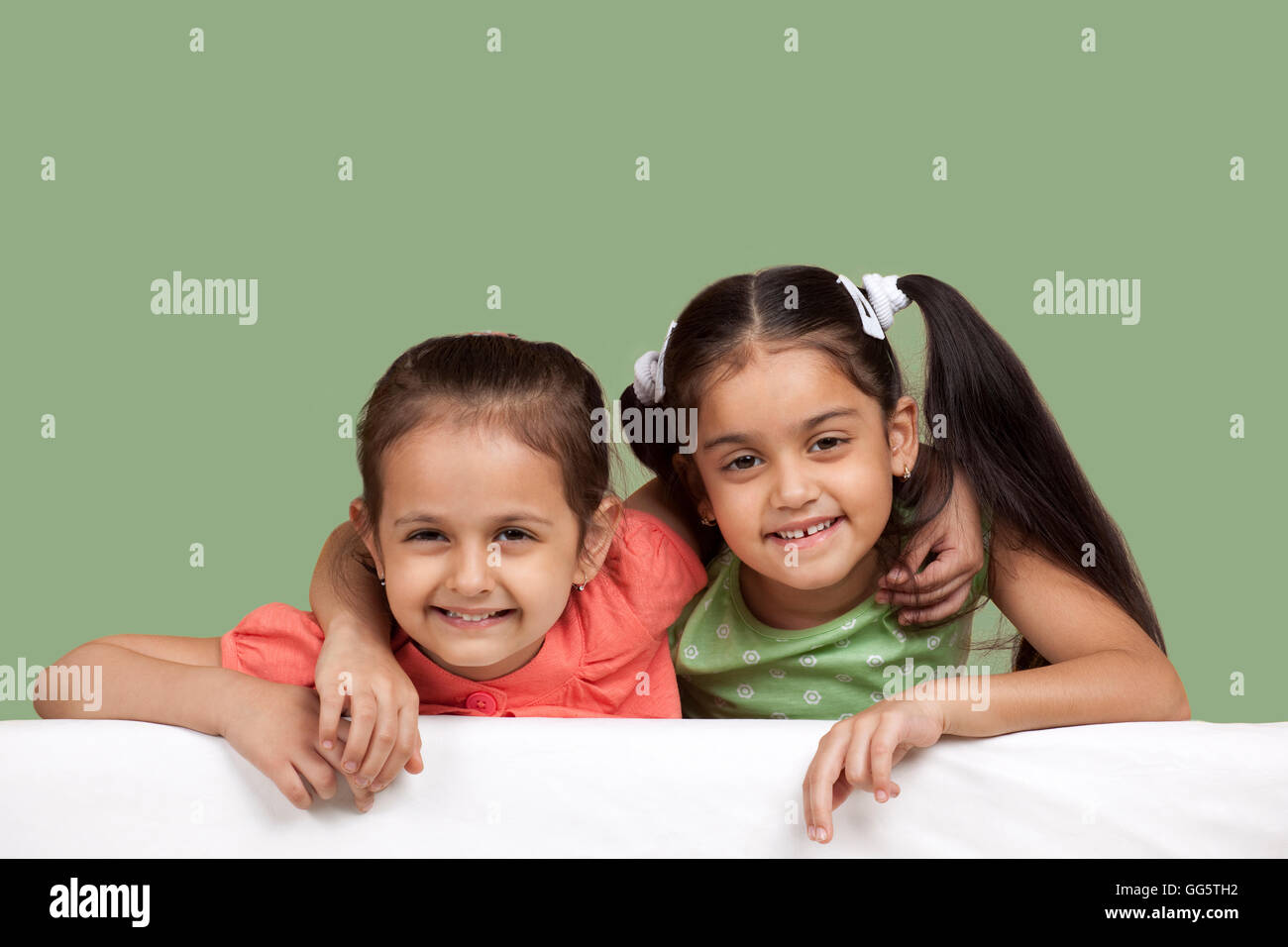 Portrait of smiling sisters over colored background Stock Photo