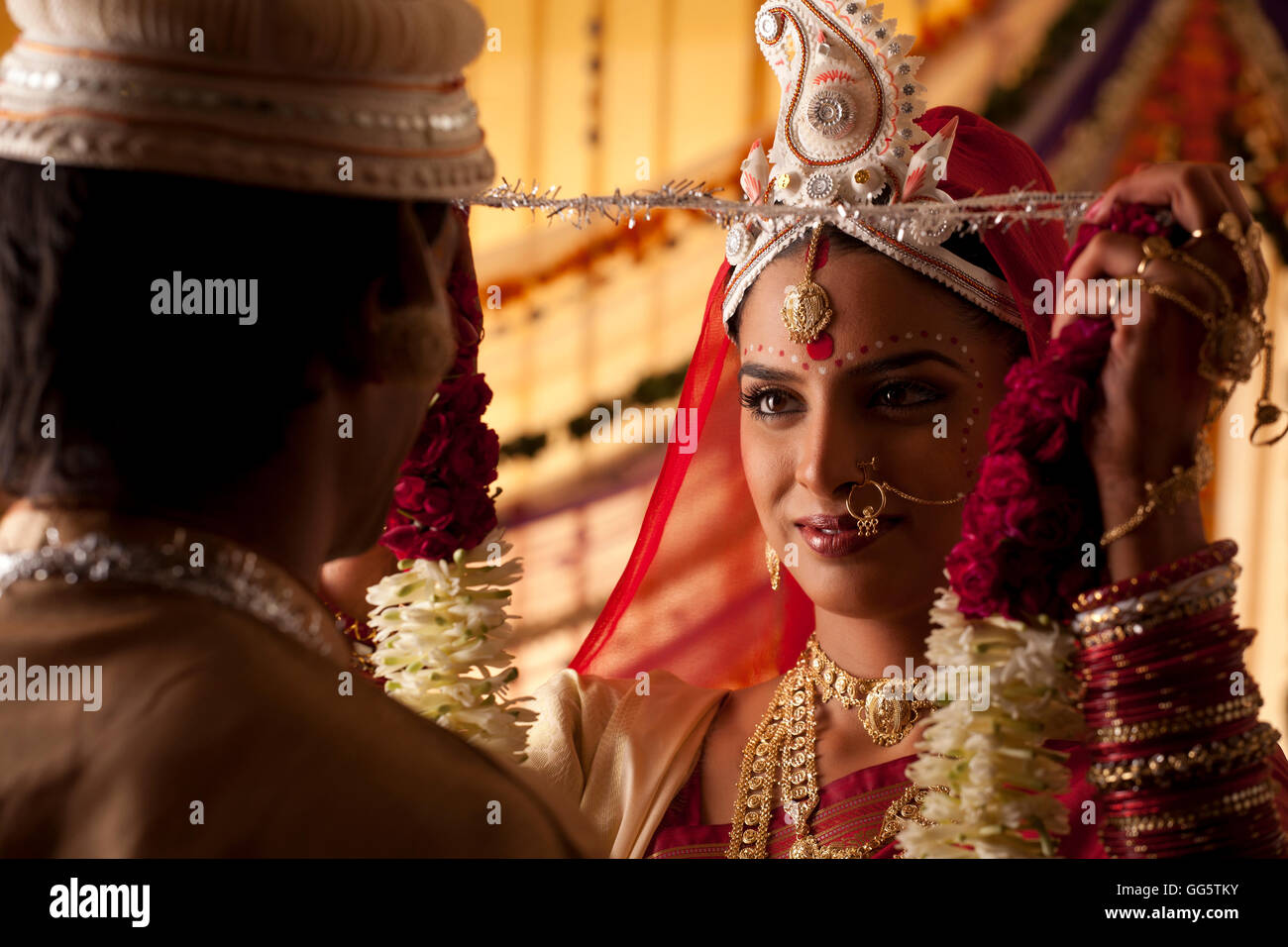 Bengali bride putting a garland on groom Stock Photo Alamy