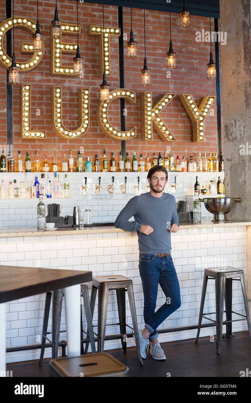 Young man standing at bar counter Stock Photo - Alamy