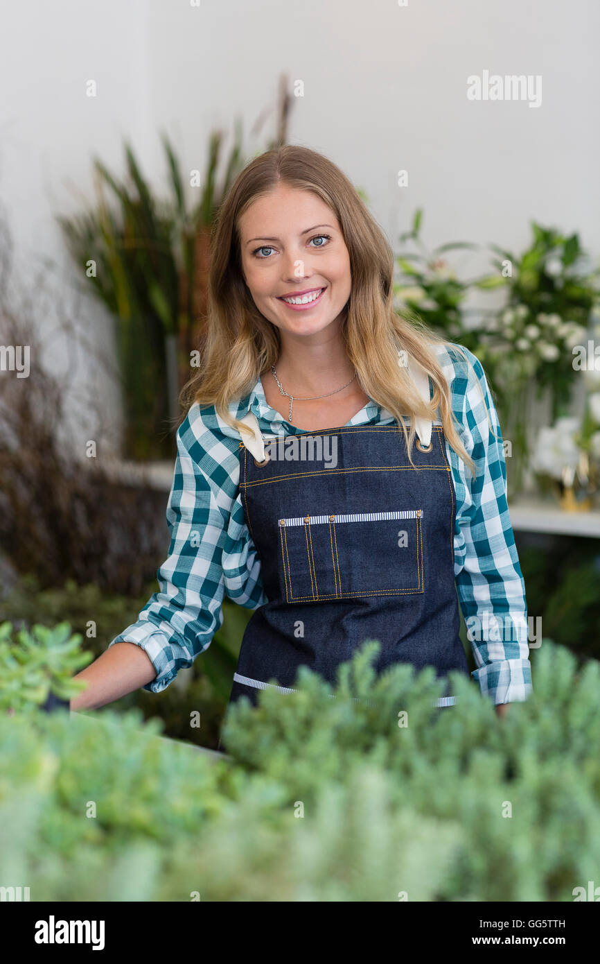 Happy woman standing at flower shop Stock Photo - Alamy