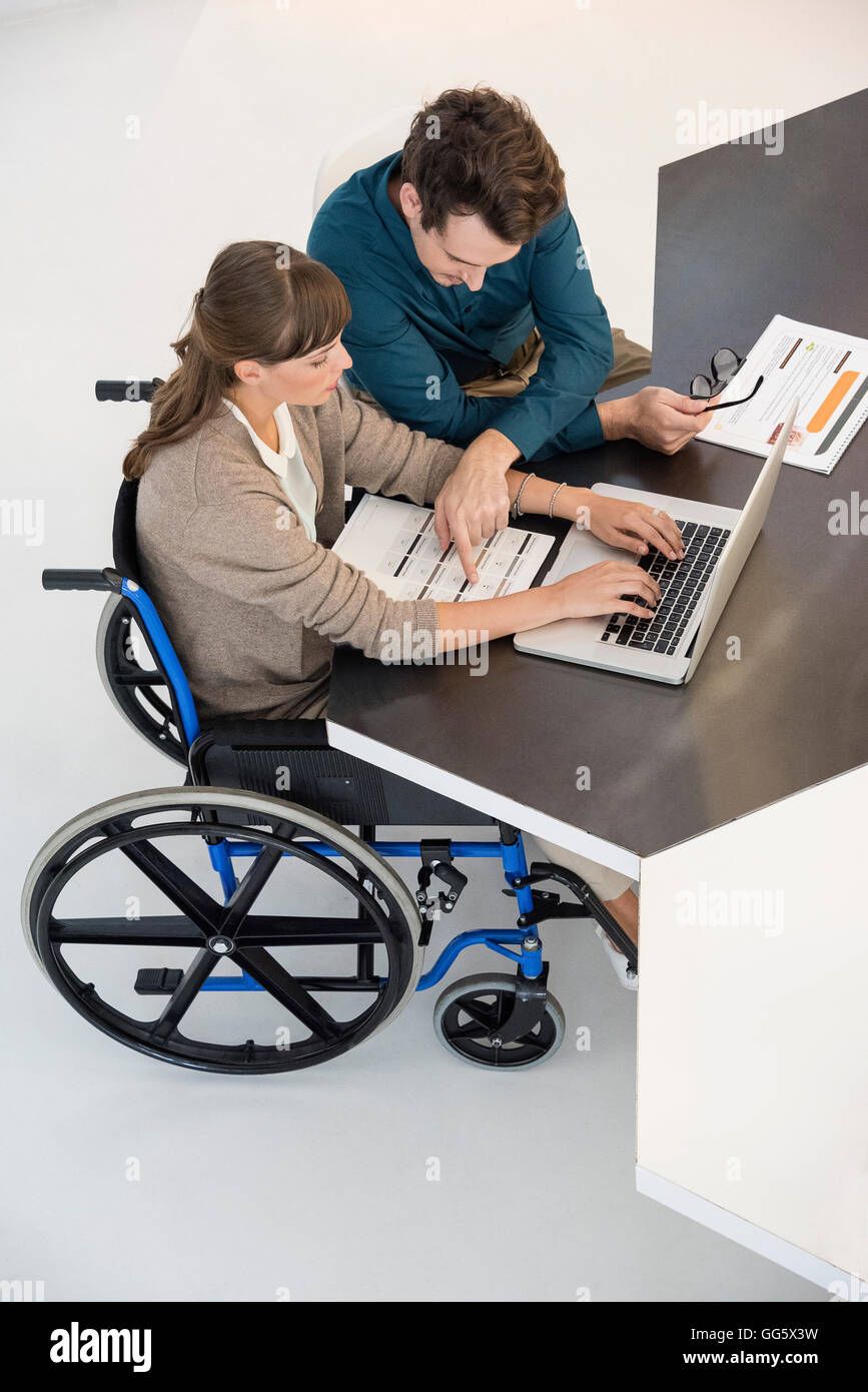 Two business people working on a laptop in an office Stock Photo