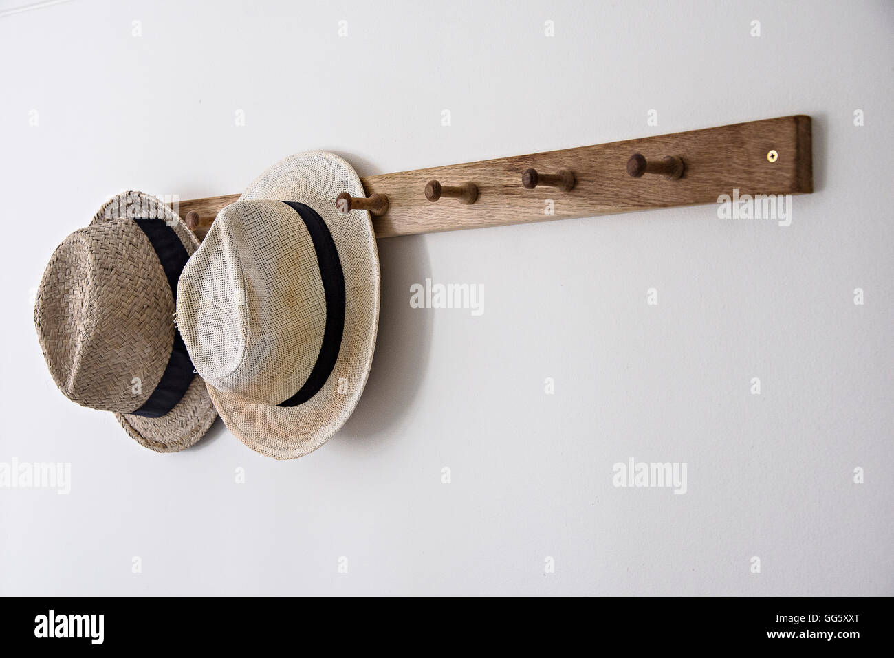 Hats hanging on hook on wall in bathroom Stock Photo