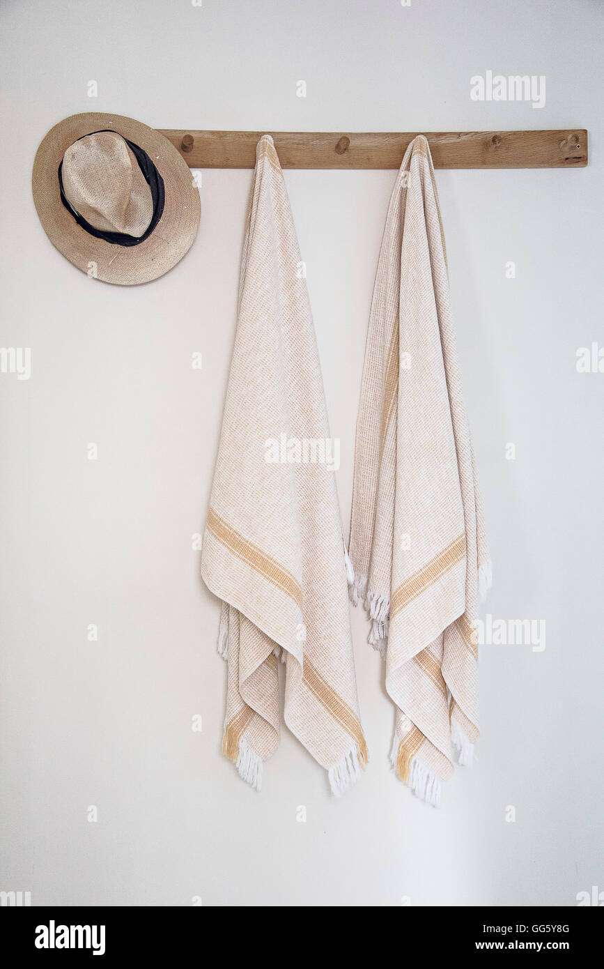 Towels hanging on hook on wall in bathroom Stock Photo