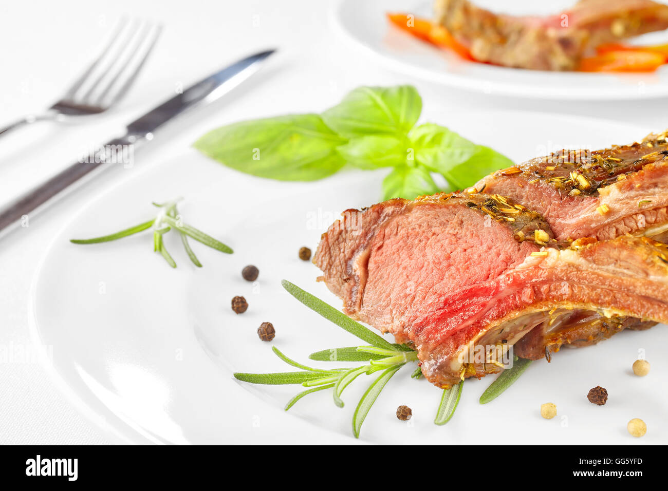 Roasted lamb rib chops on a plate, dinner setting. Stock Photo