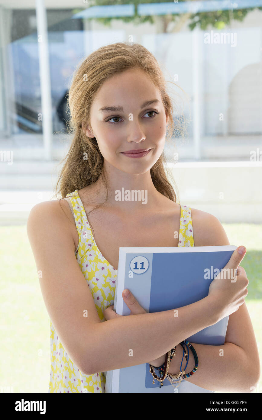 Happy teenage girl holding books Stock Photo - Alamy