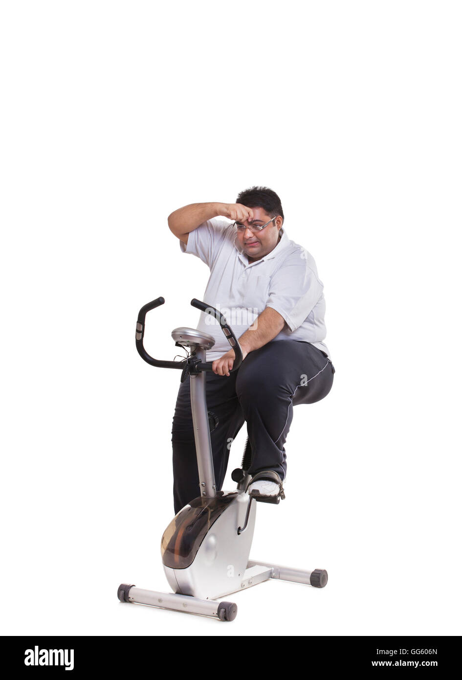 Obese man on exercise bike Stock Photo