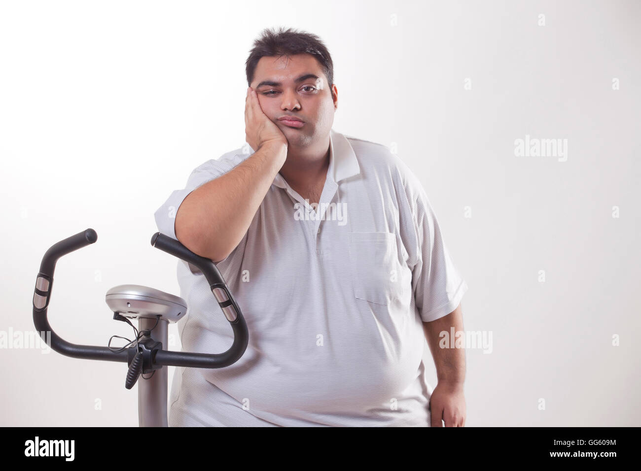 Portrait of a lazy obese man with an exercise bike over white background Stock Photo Alamy