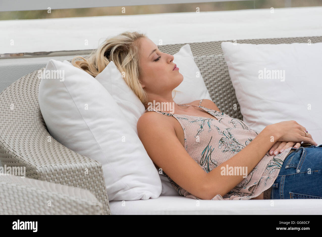 Young woman lying on a couch Stock Photo - Alamy
