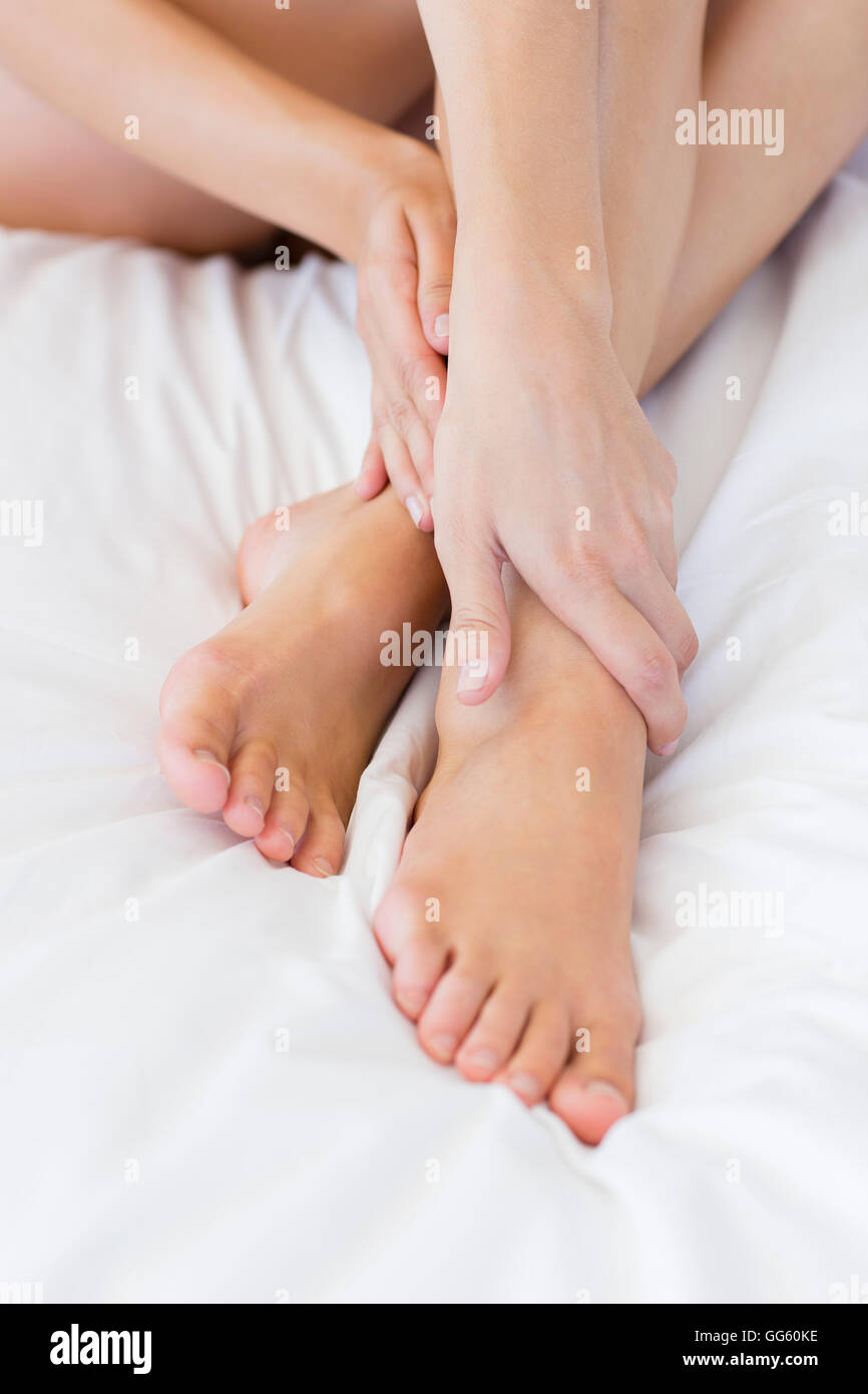 Low section view of a woman sitting on the bed Stock Photo - Alamy