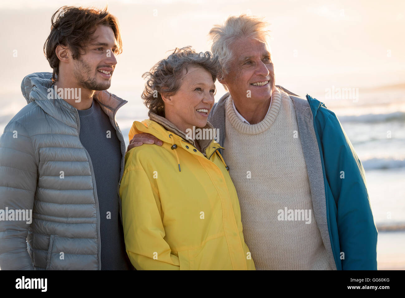 Happy family standing on the beach Stock Photo - Alamy