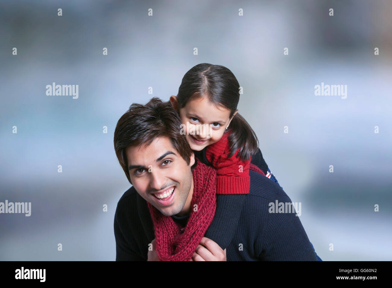 Father giving girl piggy back ride outdoors Stock Photo