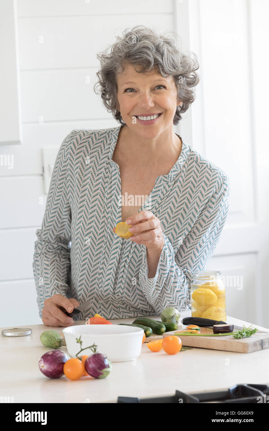 Happy woman preparing food in kitchen Stock Photo