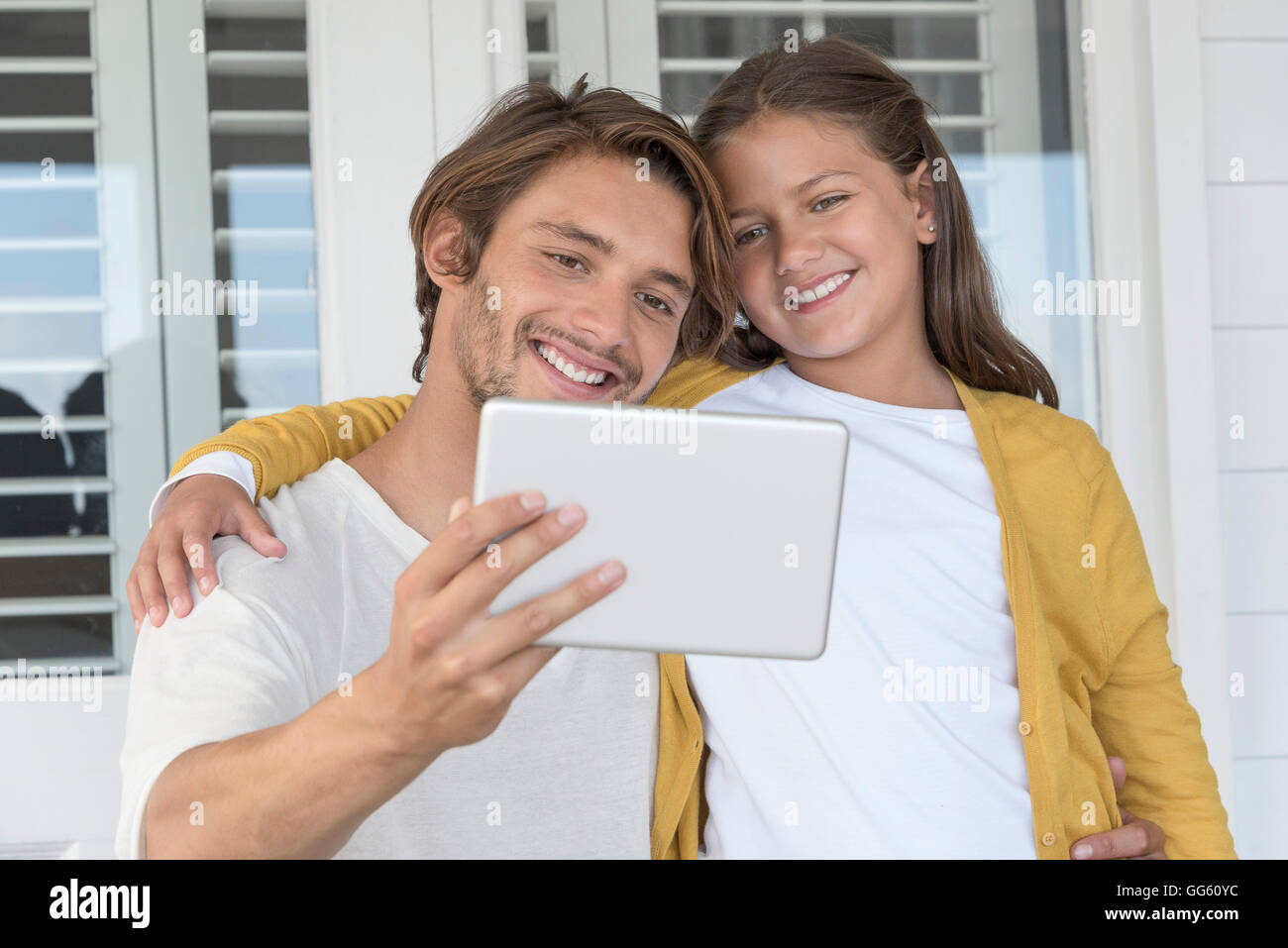 Happy father with his little daughter taking a selfie with digital tablet at home Stock Photo