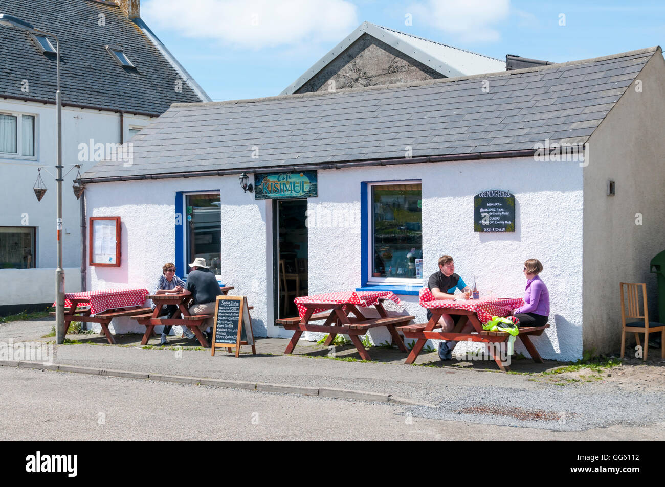 People sitting outside Cafe Kisimul in Castlebay on the island of Barra in the Outer Hebrides, Scotland. Stock Photo
