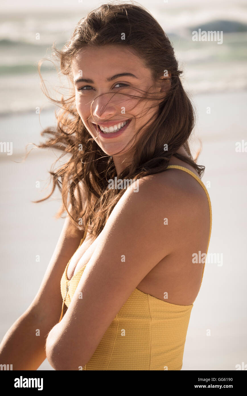 Happy young woman standing on the beach Stock Photo
