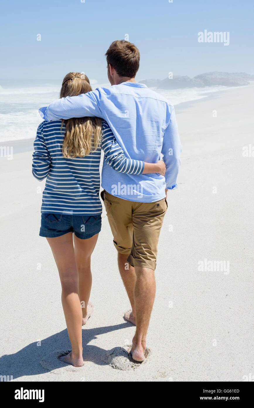 Rear view of a couple walking on the beach Stock Photo - Alamy
