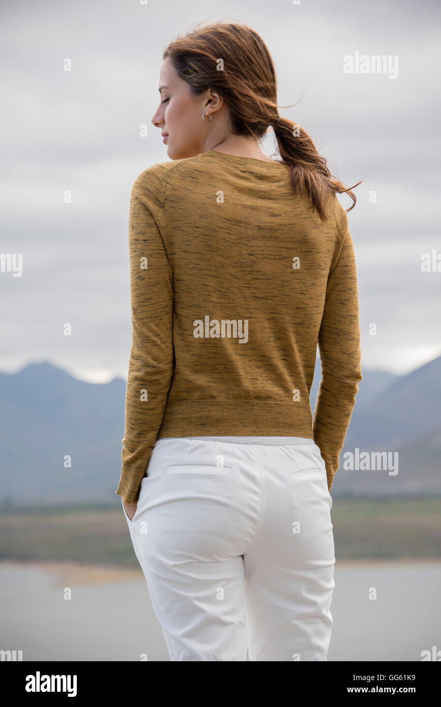 Rear view of a woman standing at lakeshore looking at view Stock Photo ...