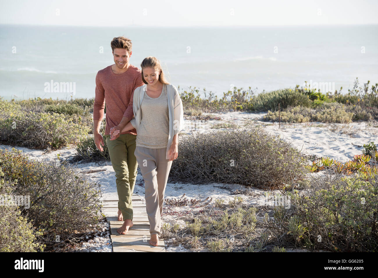 Happy couple walking on the beach Stock Photo - Alamy