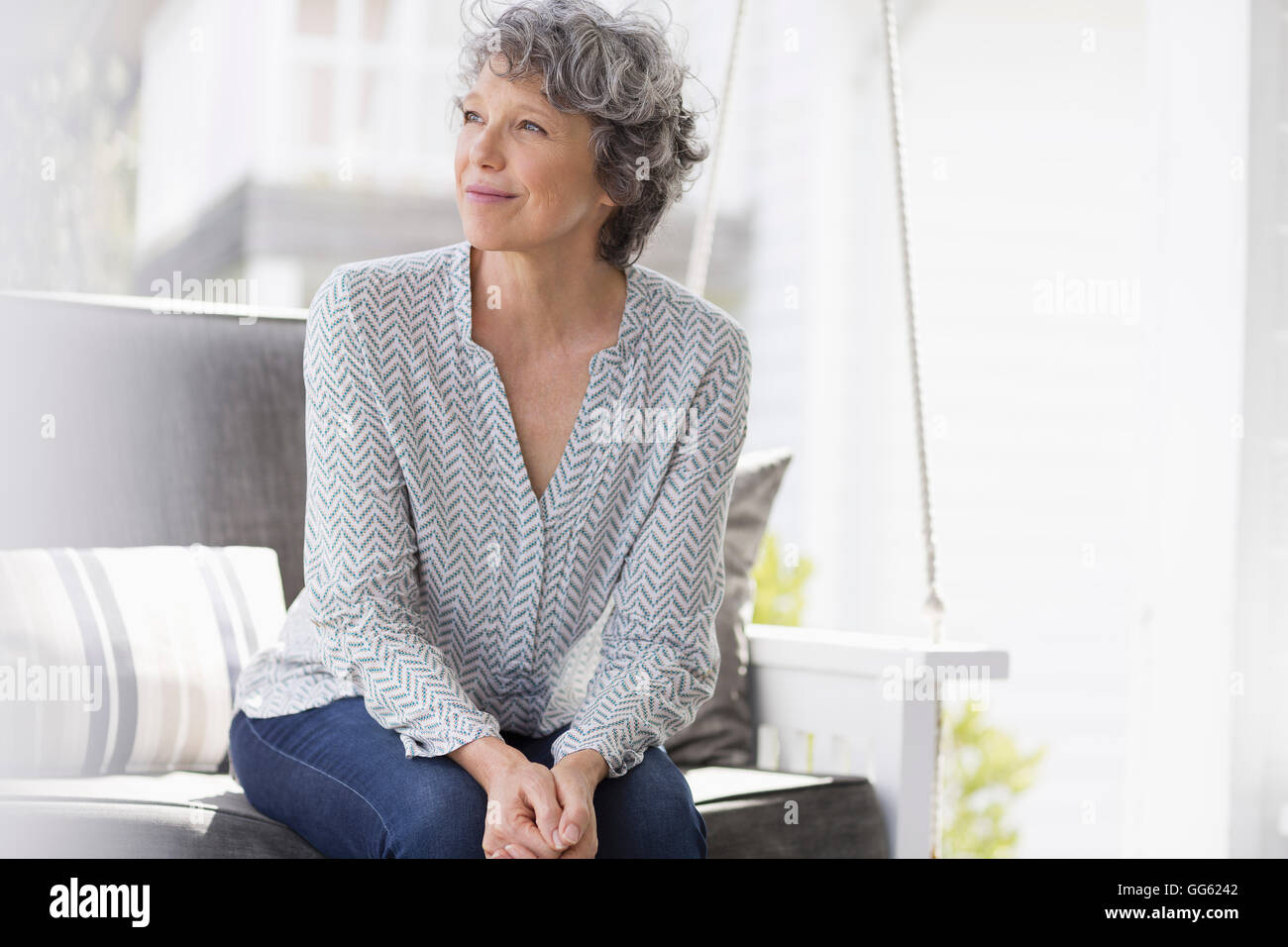 Woman sitting on a swing and day dreaming Stock Photo