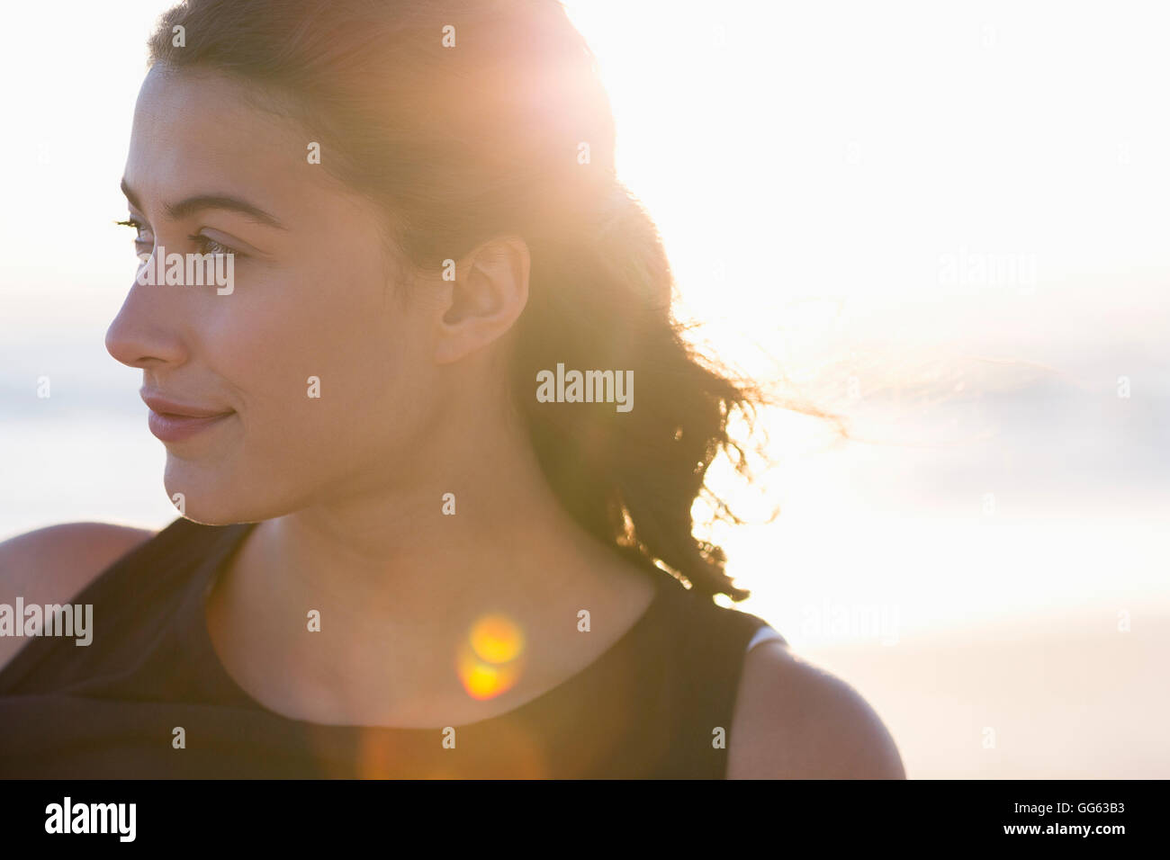 Beautiful young woman standing on the beach Stock Photo - Alamy