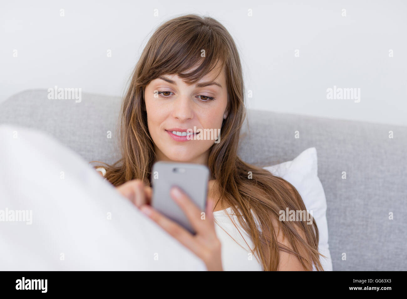 Happy beautiful young woman messaging with a mobile phone Stock Photo