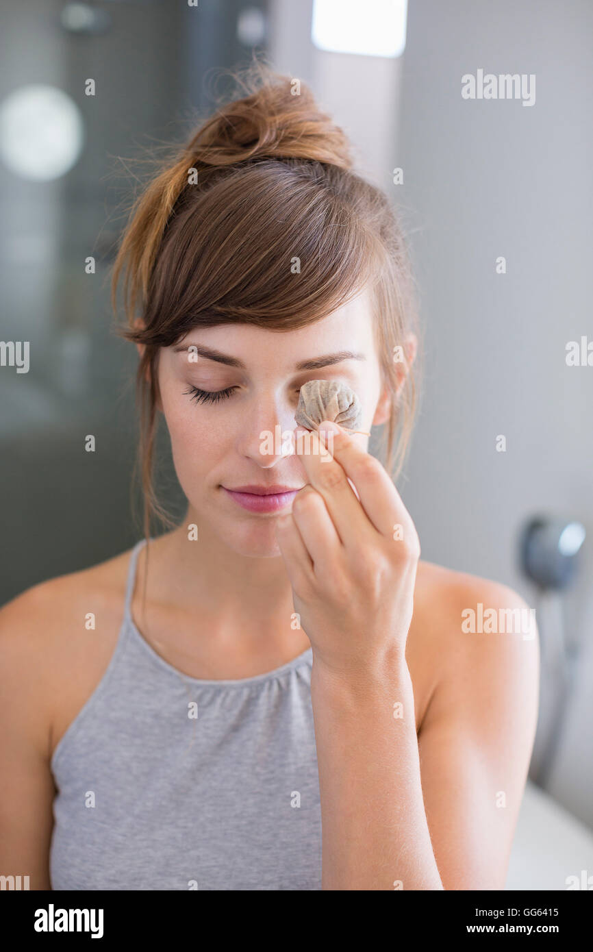 Beautiful woman holding tea bags in front of her eye Stock Photo Alamy
