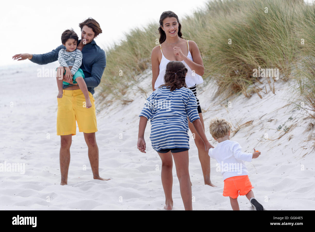 Happy young family enjoying on beach Stock Photo