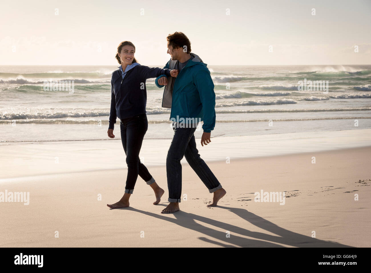 Beach couple barefoot walking hi-res stock photography and images - Alamy