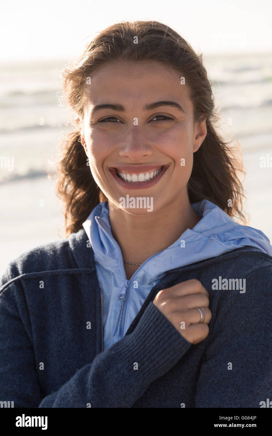 Pretty young woman smiling on the beach Stock Photo - Alamy