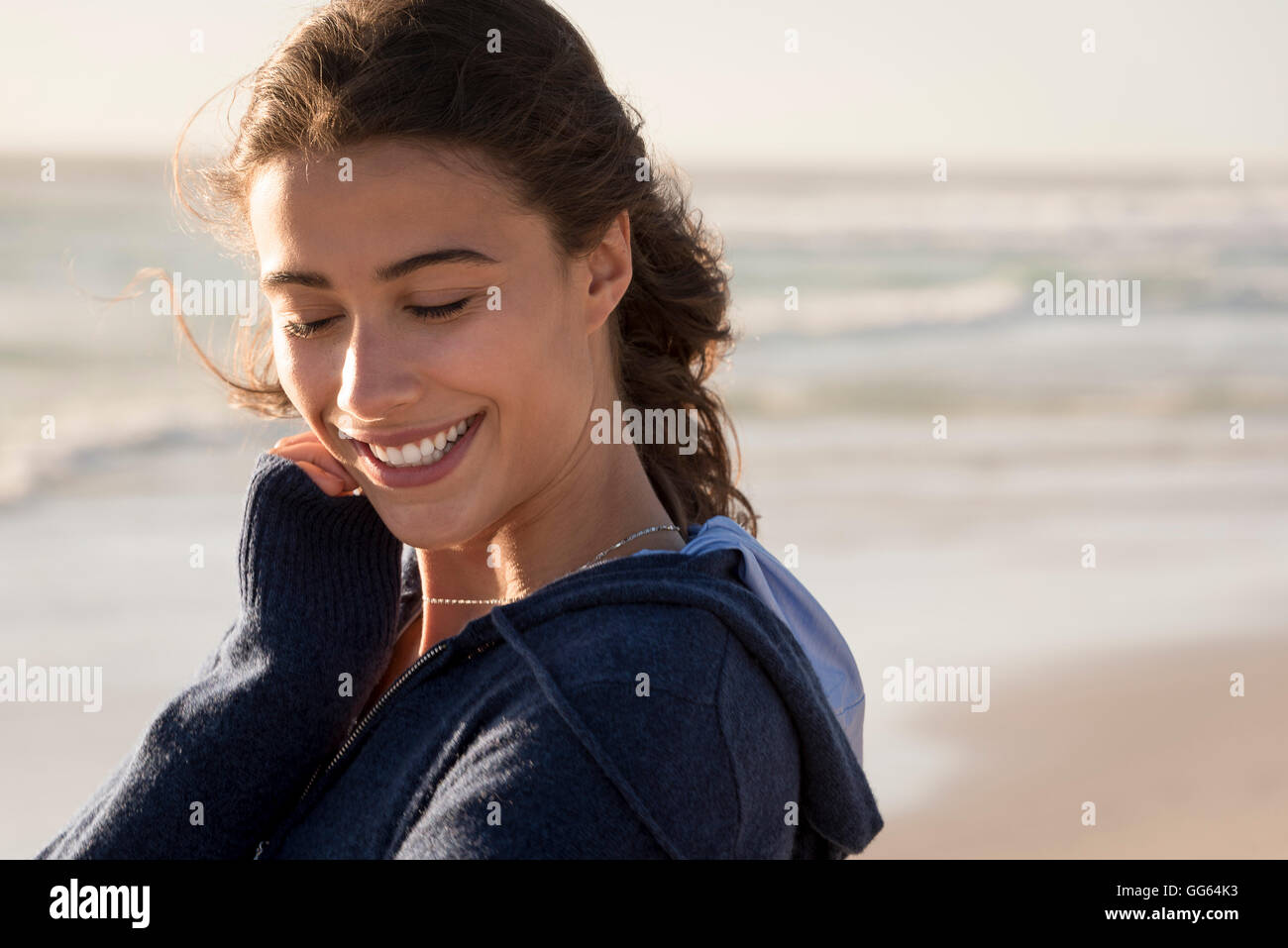 Beautiful young woman smiling on the beach Stock Photo - Alamy