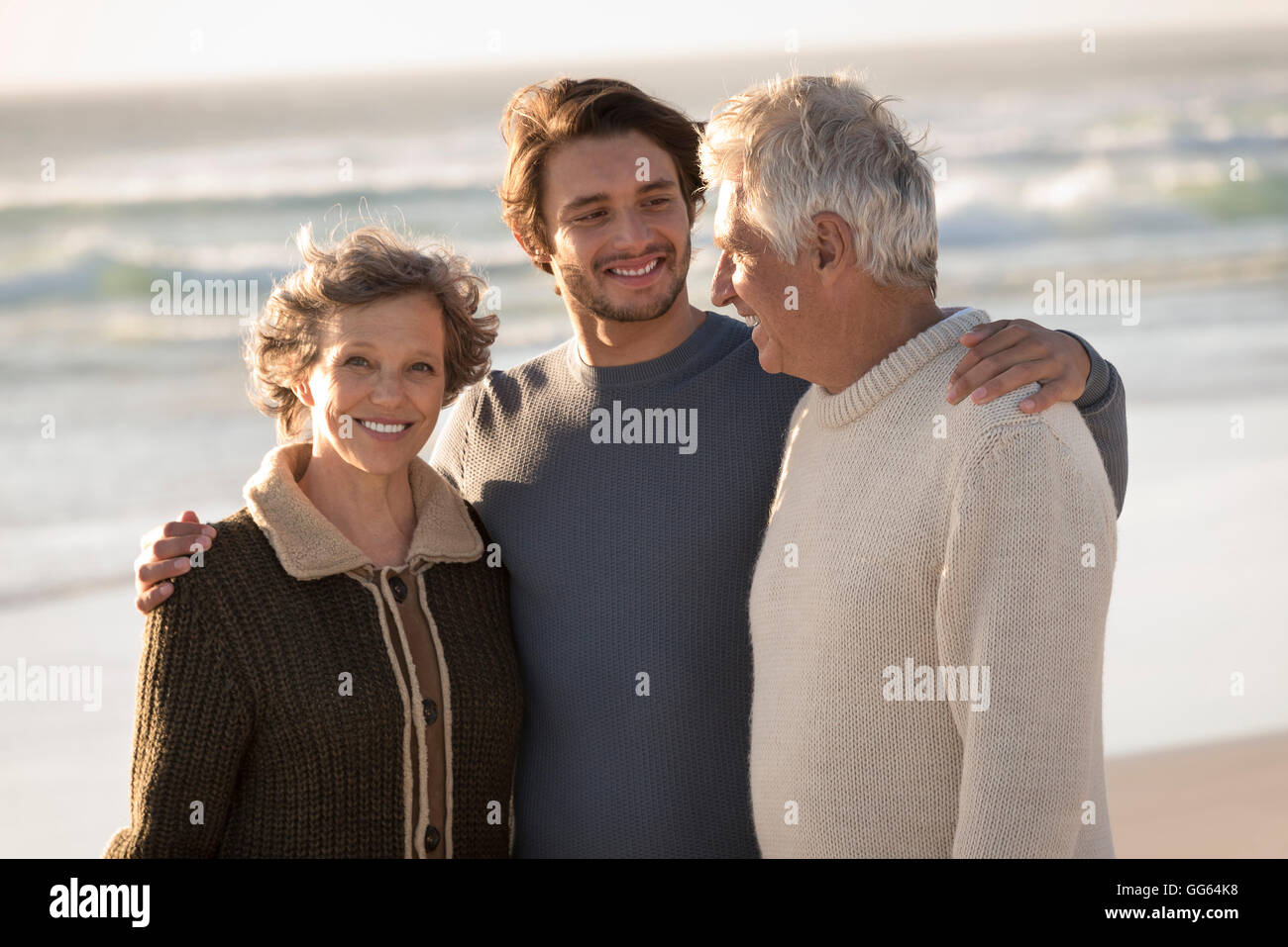 Happy family standing on the beach Stock Photo - Alamy