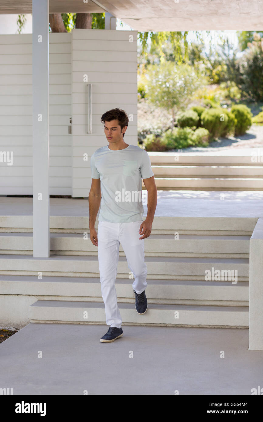 Young man moving down staircases Stock Photo
