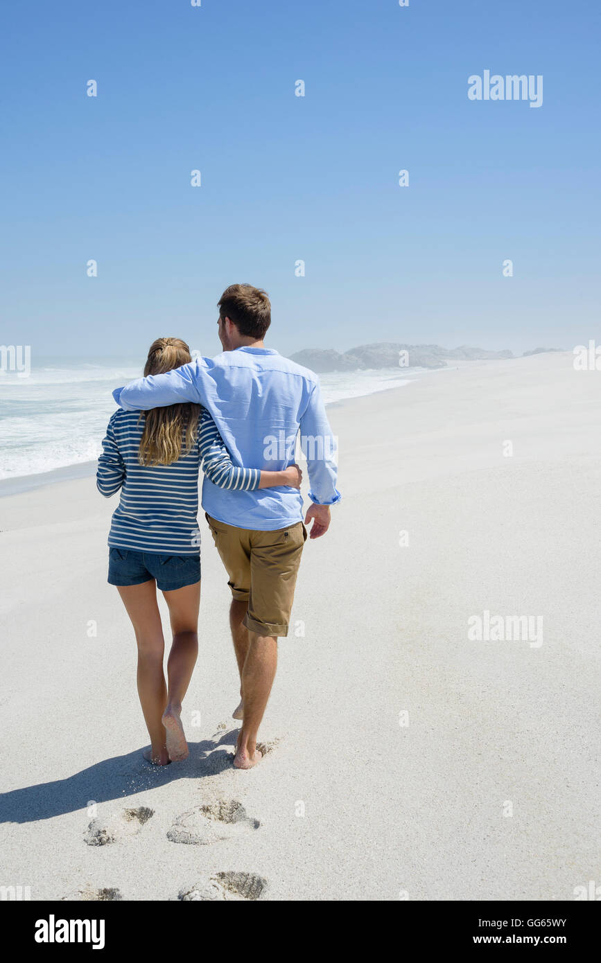 Rear view of a couple walking on the beach Stock Photo - Alamy
