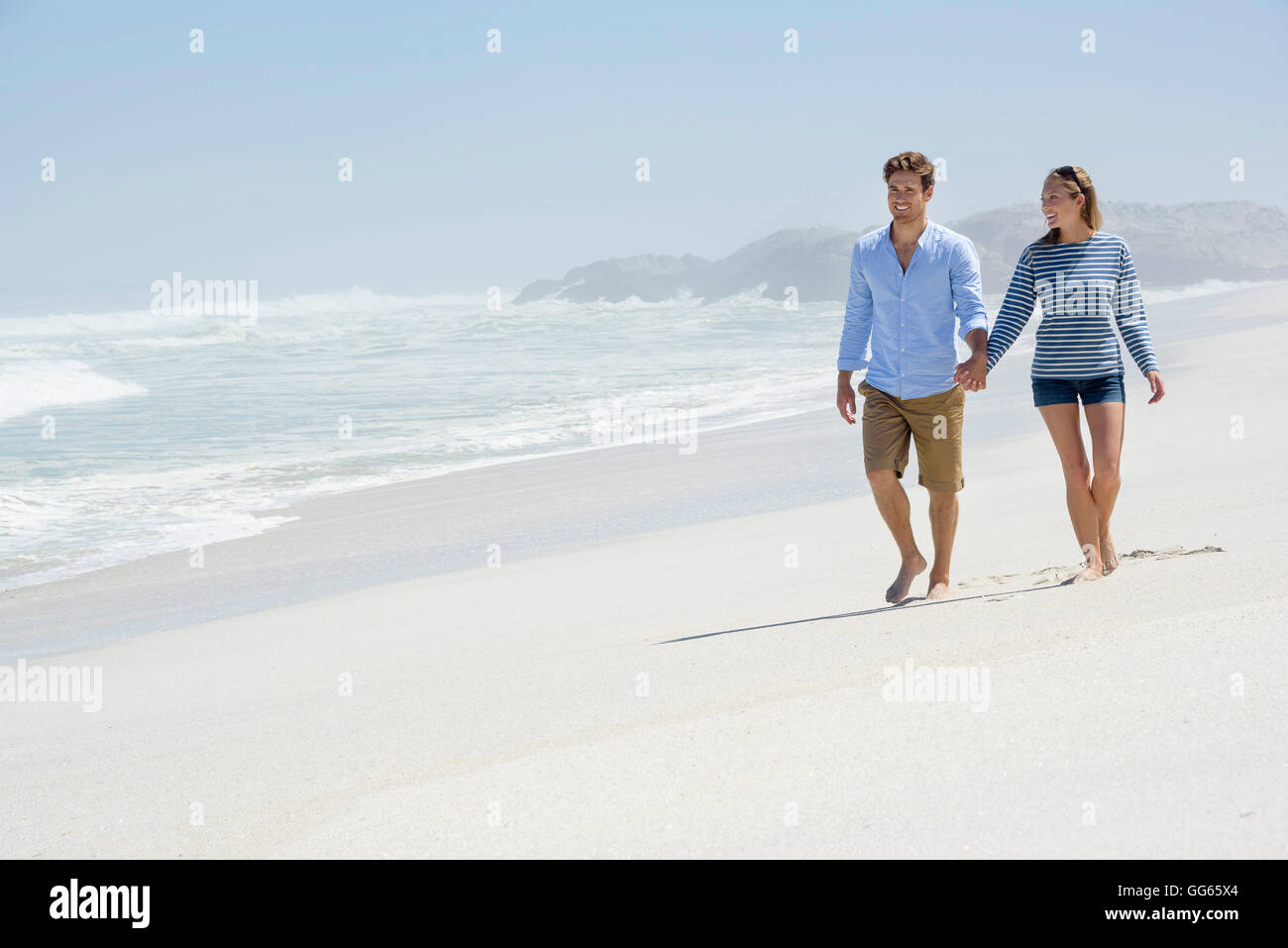 Happy couple walking on the beach Stock Photo - Alamy