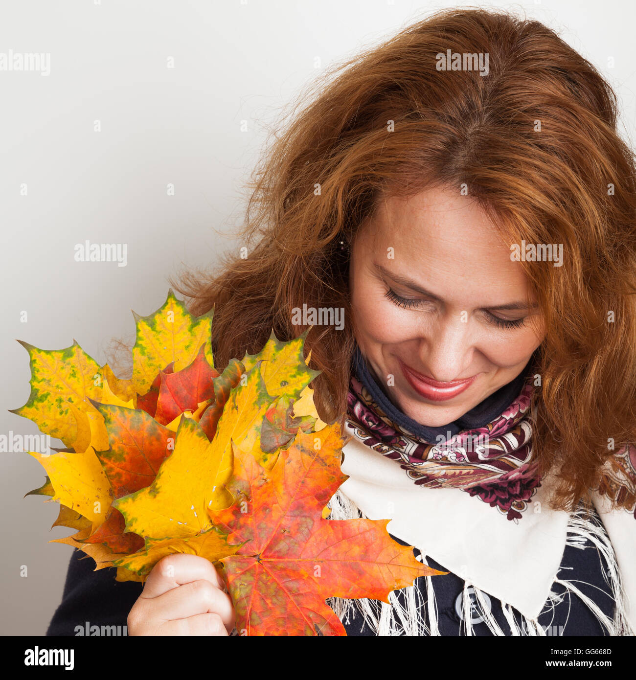 Portrait of beautiful smiling Young woman with colorful autumn maple leaves, square photo Stock Photo
