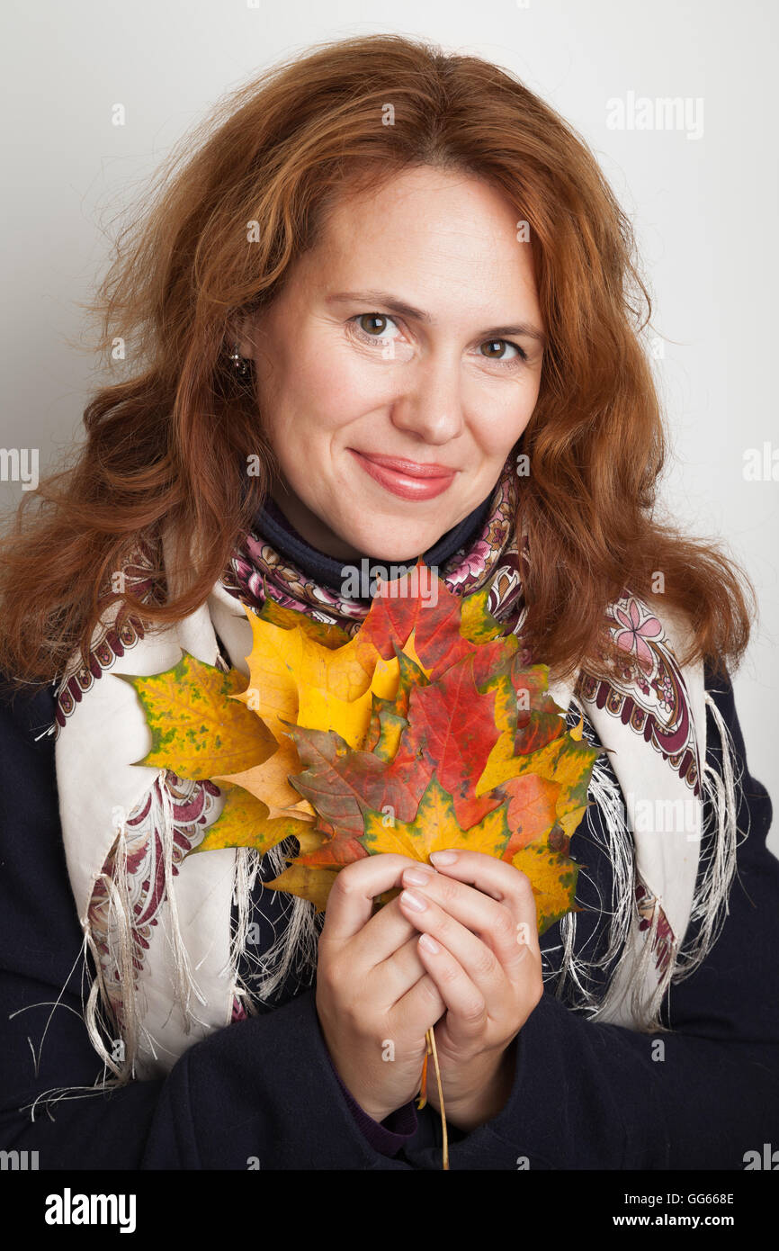 Portrait of beautiful smiling Young Caucasian woman with colorful autumn maple leaves Stock Photo