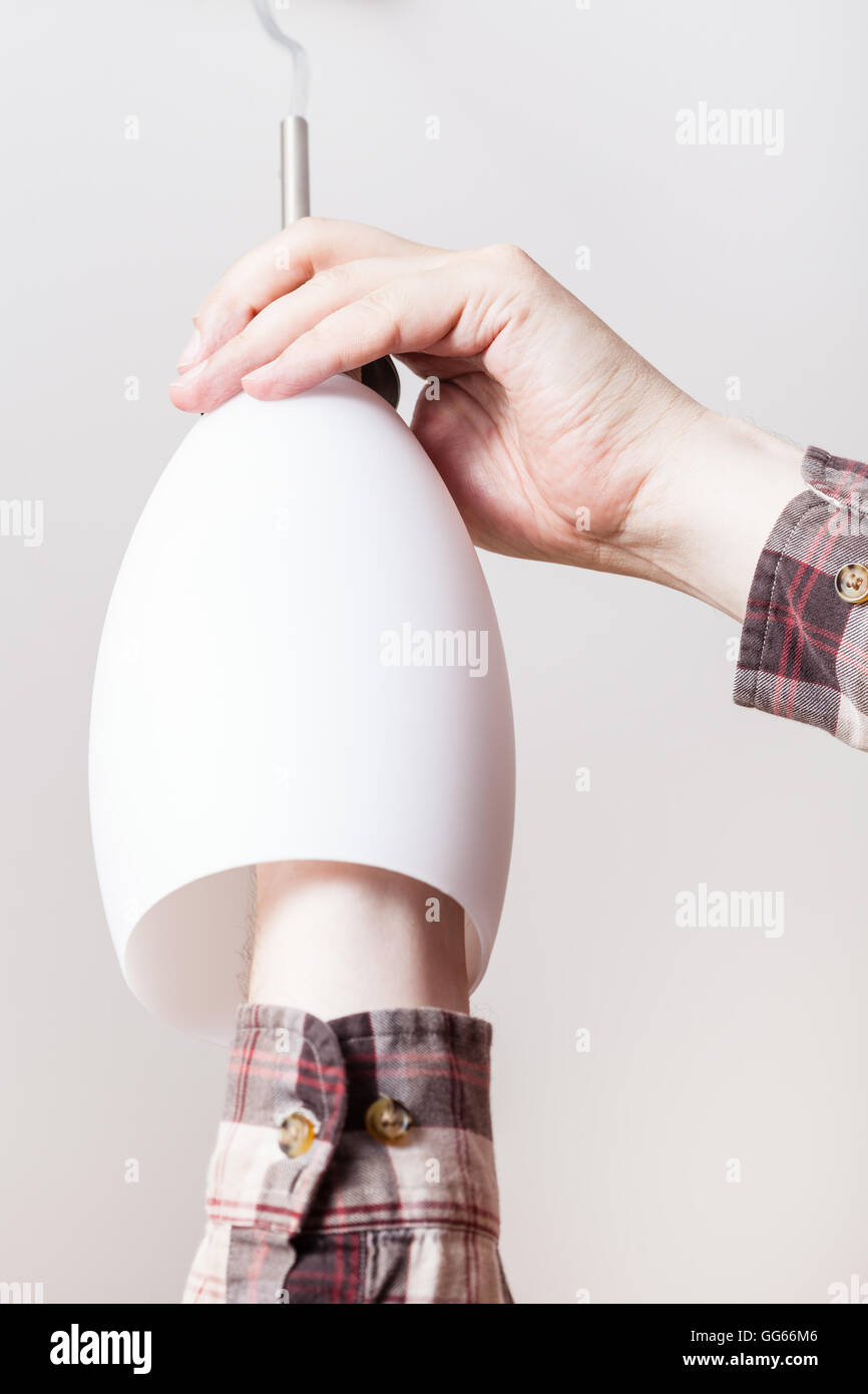 Electrician Changing Lamp In Glass Ceiling Lights In Room Stock