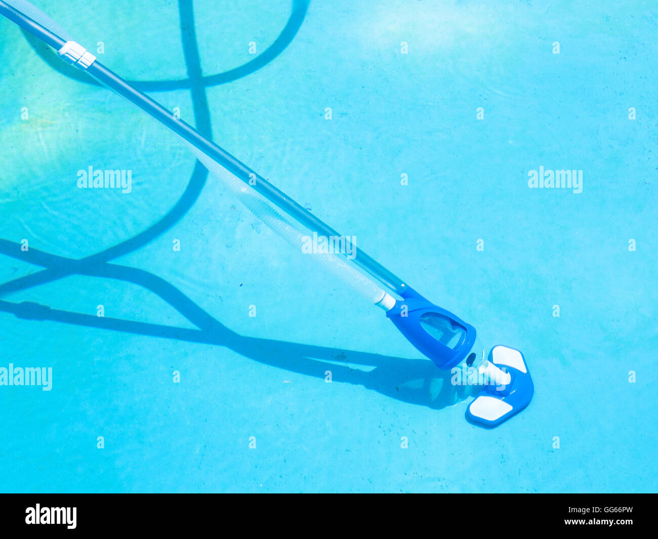 cleaning bottom of swimming pool by underwater vacuum cleaner Stock