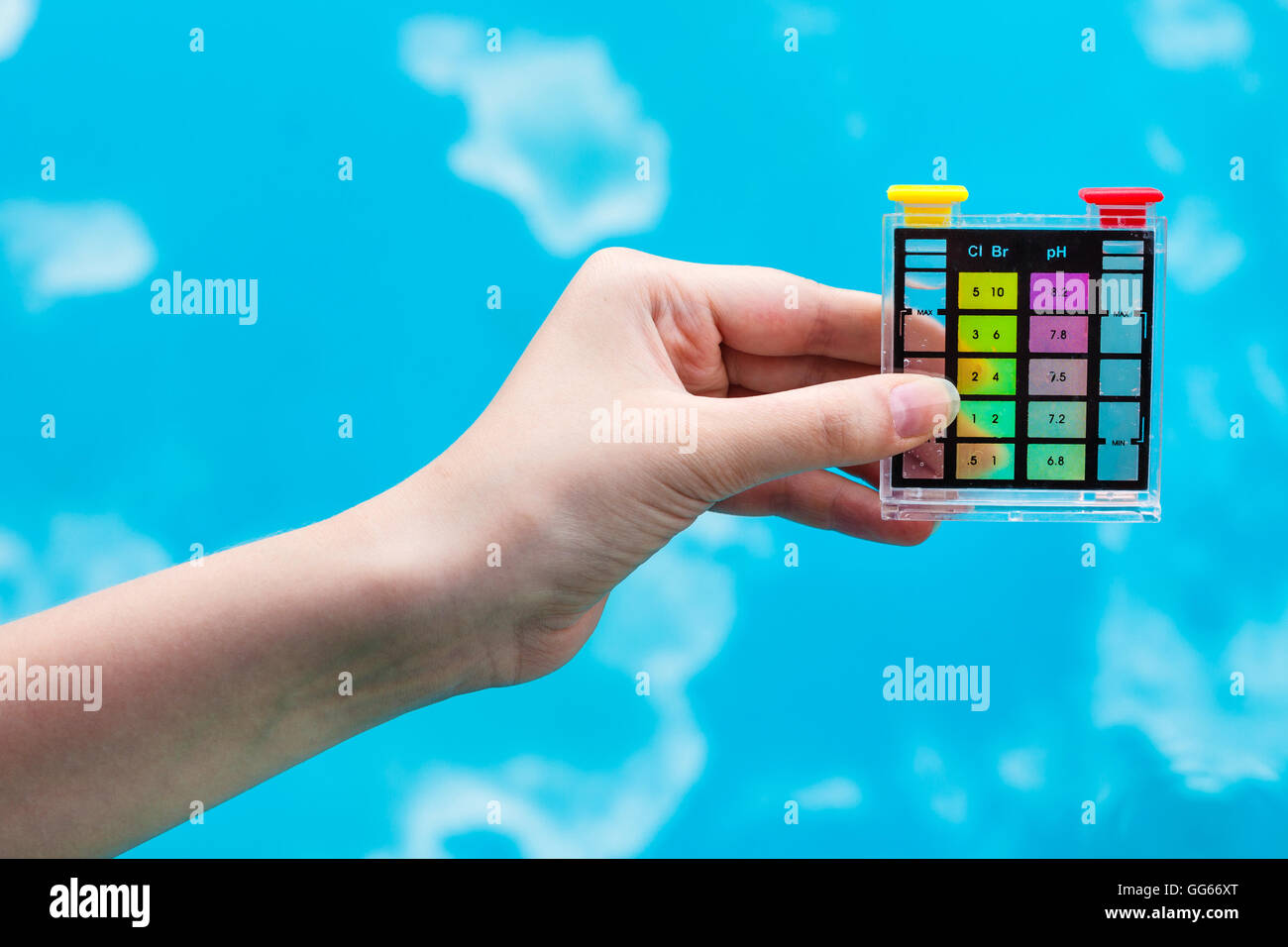measuring pH level in blue outdoor pool by chemical tester Stock Photo
