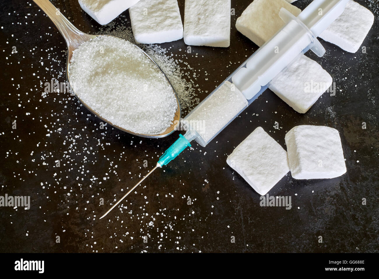 Injection with needle filled with sugar on black rustic background. Concept image for sugar addiction. Top view with copy space Stock Photo